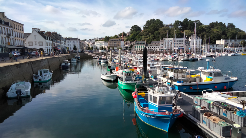 Photo of the port of Audierne with fishing boats in the foreground, then sailboats and finally, 
					houses in the background